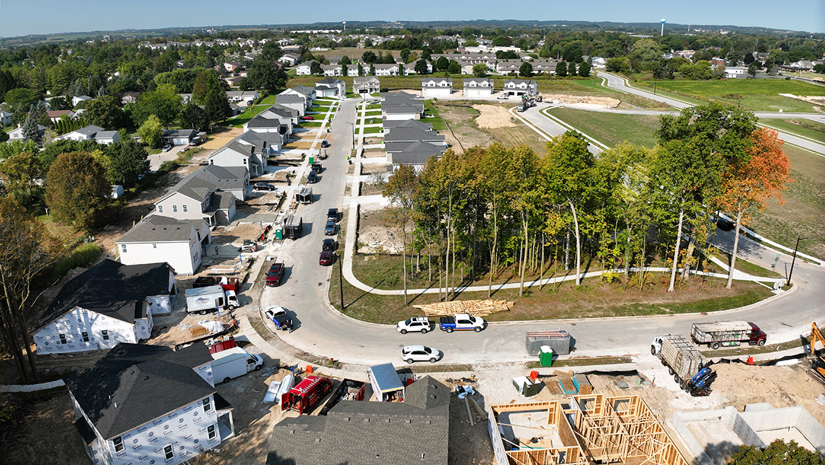 Aerial view of suburban housing development under construction with new homes and roads.