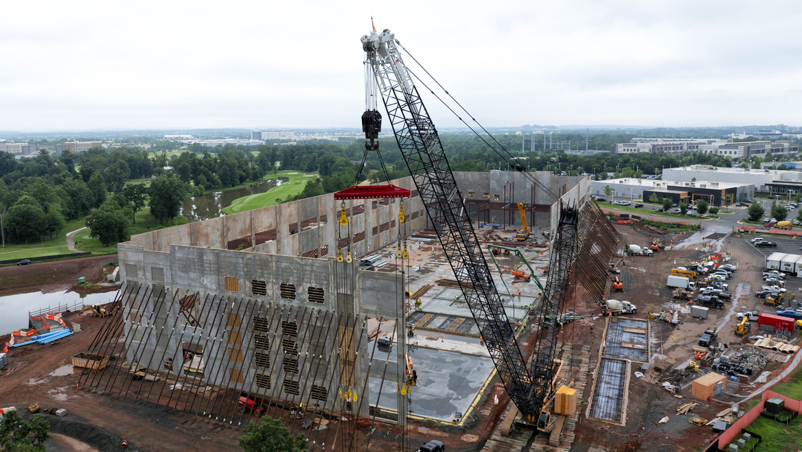 A crane is the forefront of a concrete data center being constructed.