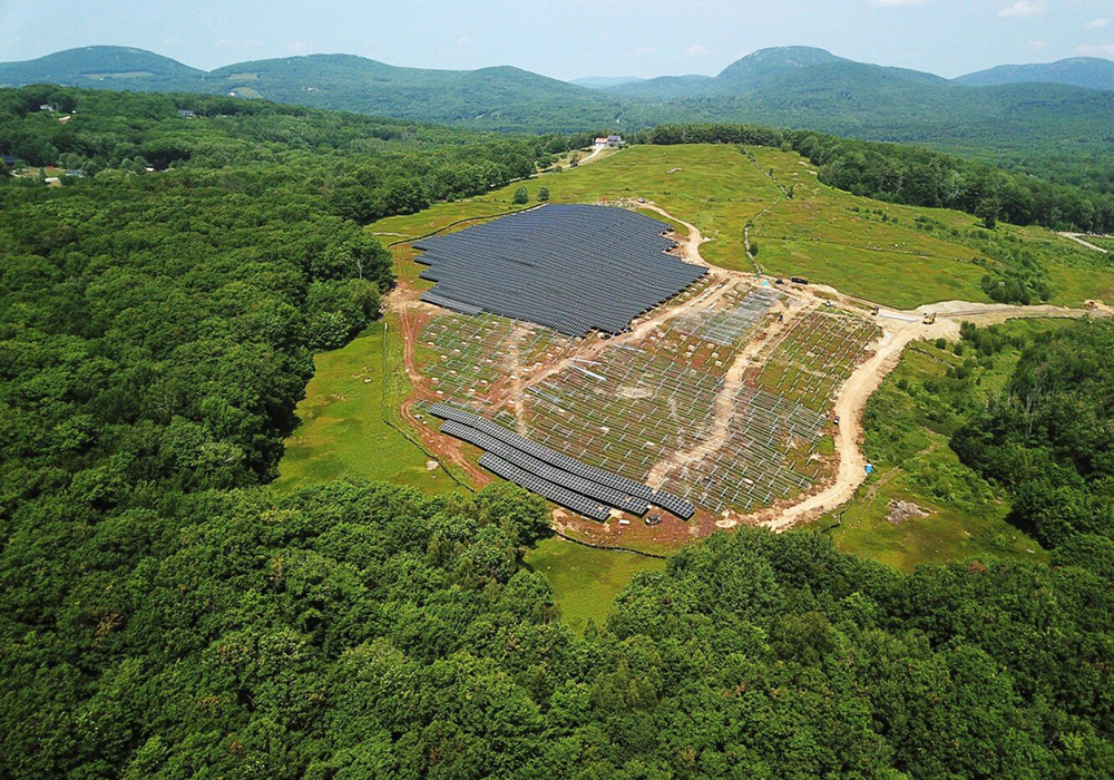 Rows of solar arrays separated by a large contiguous area of crops.