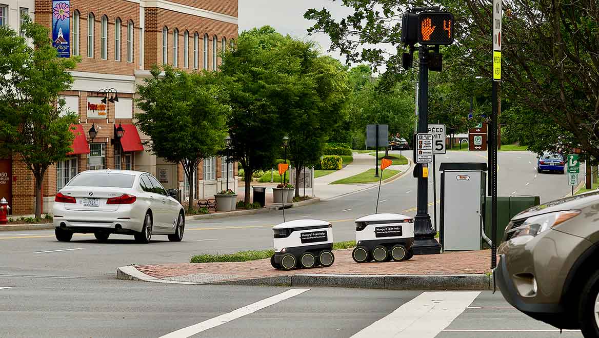 In Fairfax, Virginia, delivery robots wait to cross the street. An influx of robots could pose new safety and accessibility challanges. Photo by John M. Chase/iStock Unreleased.