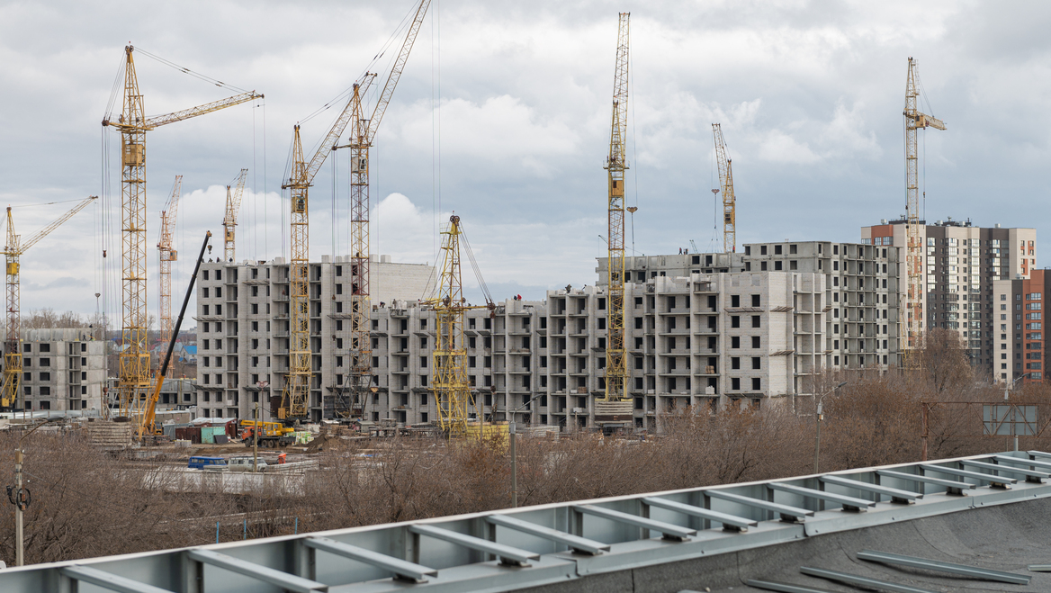 A series of buildings under construction with cranes.
