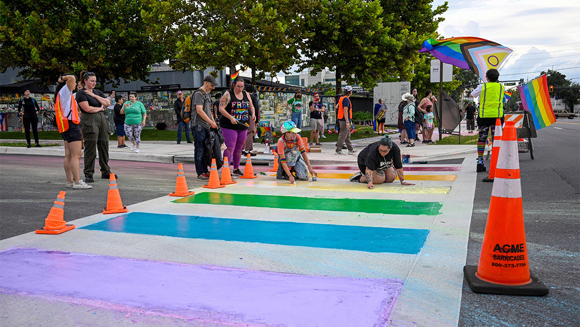 Protesters in Orlando, Florida, use chalk to restore a crosswalk memorializing victims of the Pulse nightclub shooting. The state removed the original to align with a federal transportation policy announced in August 2025. Photo by Phelan M. Ebenhack.