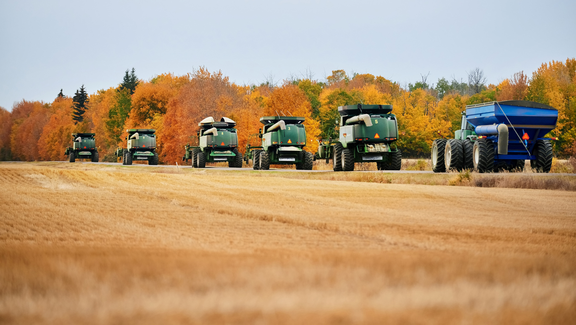 Tractors drive to harvest crops on a farm.