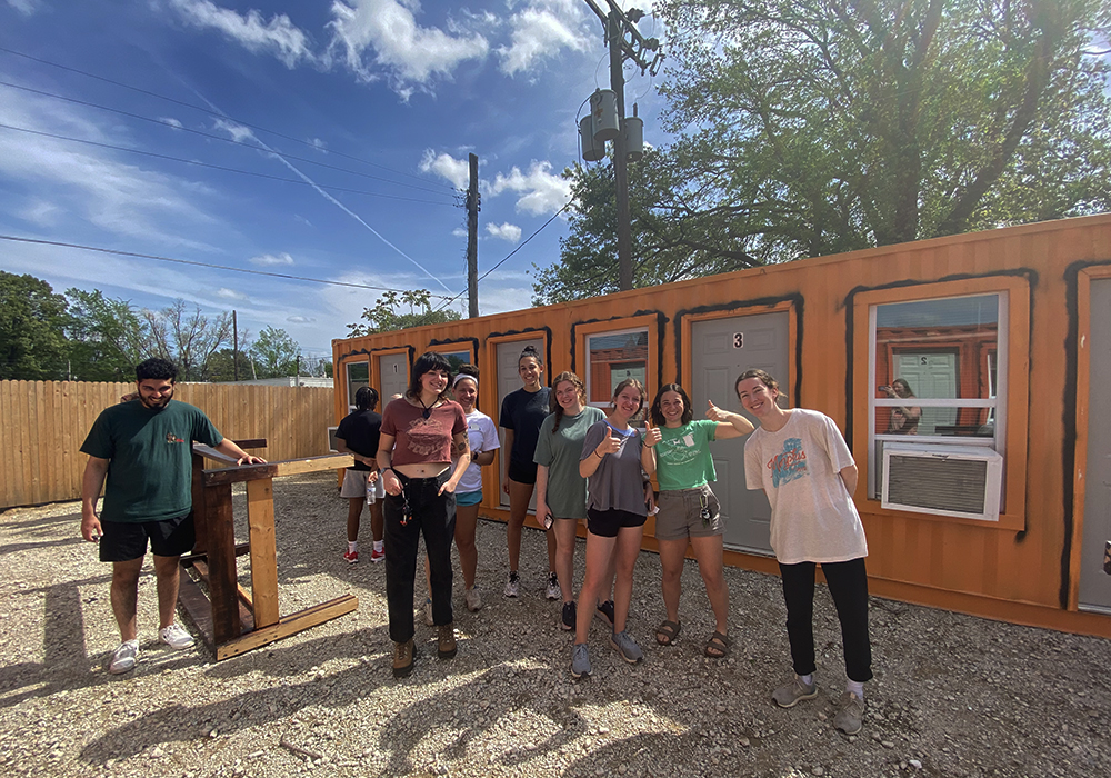 Students from Mound Up! team recruited other students to come canvass in the neighborhood. After canvassing, students checked out the transitional housing built by housing topic leader Dwayne Jones. The first storage container transitional housing project in the city.