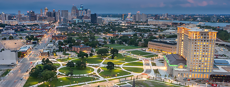 Aerial view of Detroit's downtown at dusk, with Roosevelt Park in the foreground.