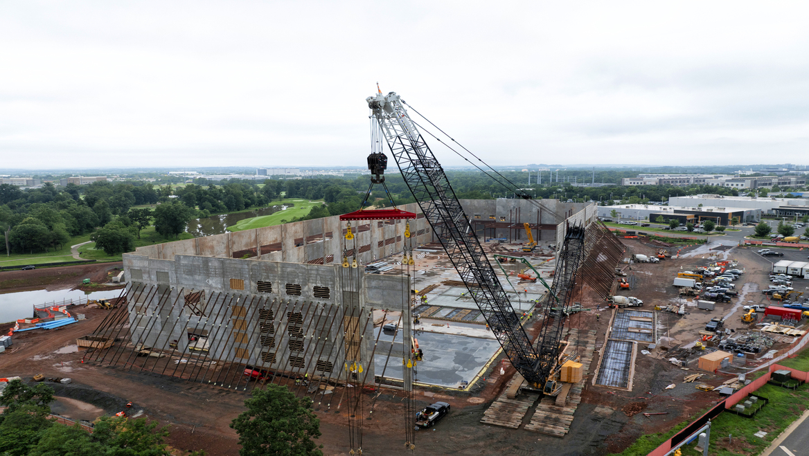 A crane is the forefront of a concrete data center being constructed.