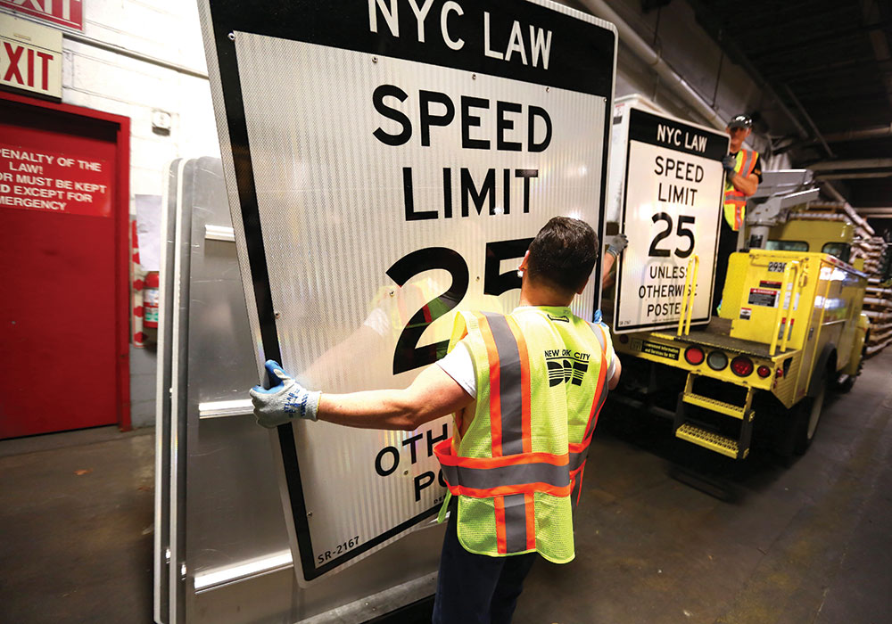 New York City Transportation Department workers ready new speed-limit signs after the city debuted the country’s first Vision Zero initiative in 2014. Photo by Chang W. Lee/The New York Times.