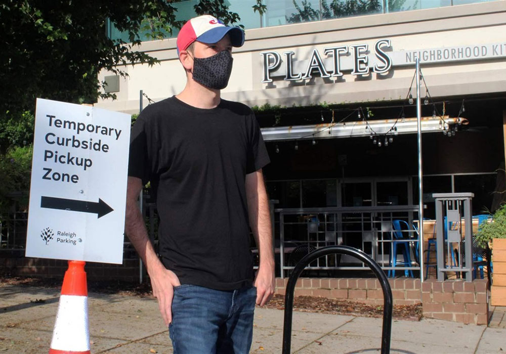 In downtown Raleigh, North Carolina, Justin Gallus stands outside his Plates Neighborhood Kitchen restaurant and one of the city-created curbside pickup zones that’s helped the business stay afloat during the pandemic. Photo courtesy Pew Charitable Trusts.