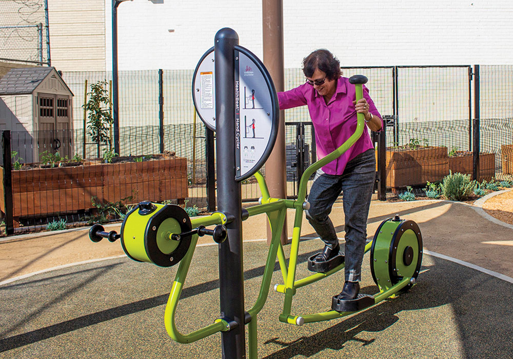 A UCLA professor tries out the equipment at an all-ages CLT park in Los Angeles she designed with residents. Photo by Mary Braswell/UCLA Luskin School of Public Affairs.