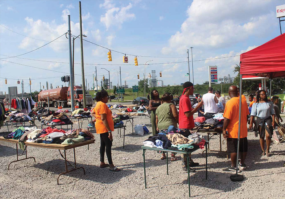 A church pop-up offers free clothing in the shadow of the refinery.