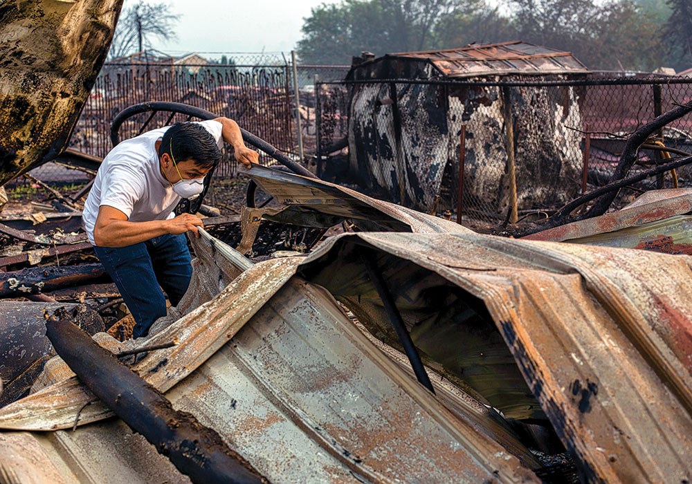 Moses Reyes searches the wreckage of his mobile home in Talent, Oregon, following the Almeda Fire. More than 2,300 homes were destroyed in the blaze. Photo by Alisha Jucevic/The New York Times.