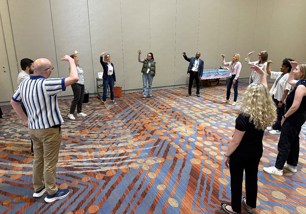 Improv teaching artist Lainie Hodges helps the group learn icebreakers and engagement strategies for community meetings.