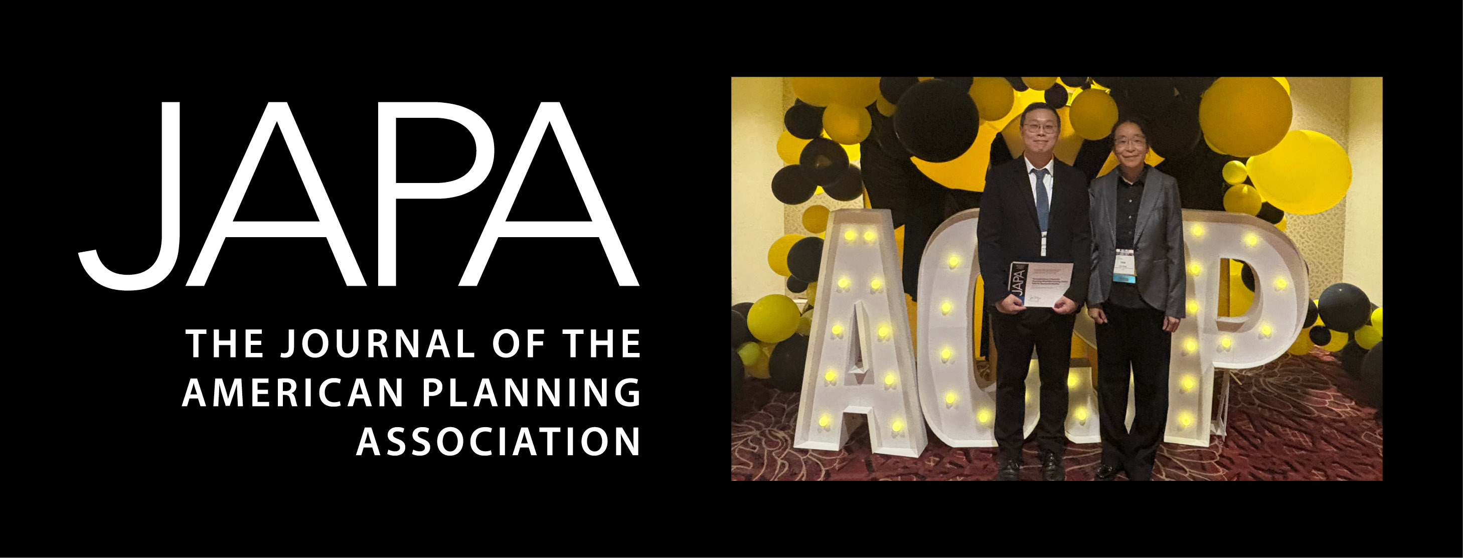 Taesoo Song and Yan Song stand by illuminated ACSP sign.