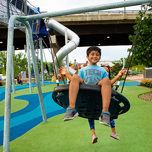 The playground offers river views and equipment for visitors of all ages and abilities.