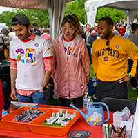 People at a flood reduction event, reviewing models and ideas. Sign reads: "What can you do to reduce flooding?
