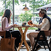 Business meeting at a cafe: man and woman discussing work over laptop.