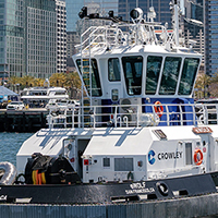 Crowley tugboat "Wolf" navigates San Diego Bay with city skyline.
