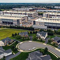 Aerial view of a large data center campus adjacent to a suburban neighborhood.