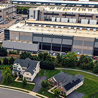 Aerial view of a large data center campus adjacent to a suburban neighborhood.