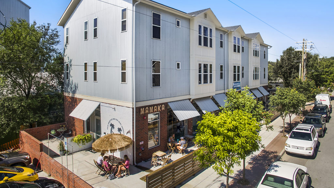 Eliminating parking minimums in 2015 catalyzed economic development in Fayetteville, Arkansas. Here, a vacant lot was transformed into a mixed-use building with nine apartments, two offices, a smoothie bar, and a taproom. Photo courtesy of Specialized Real Estate Group.