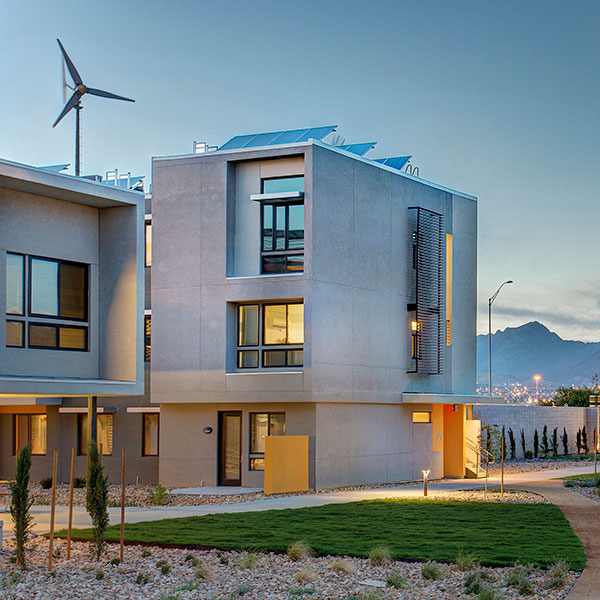 The Paisano Green Community Senior Housing development in El Paso, Texas, meets its own energy needs through a mix of energy efficiency strategies, 640 rooftop PV panels, and two 60-foot-tall Xzeres wind turbines. WORKSHOP8 designed a housing complex for El Paso’s housing authority that is 85 percent more energy efficient than the city’s building code mandates. Photo by Jesse Martinez.