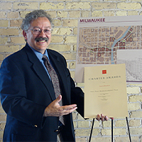 Larry Witzling with Award and Map In his 45-year career, Larry Witzling has overseen numerous award-winning urban design projects throughout Wisconsin. Photo courtesy of GRAEF.