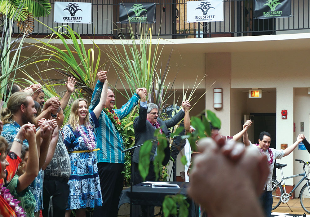 County officials and community members join hands after then-Mayor Bernard P. Carvalho (in long-sleeved blue shirt) signed the plan into law. Photo courtesy Kaua'i County.