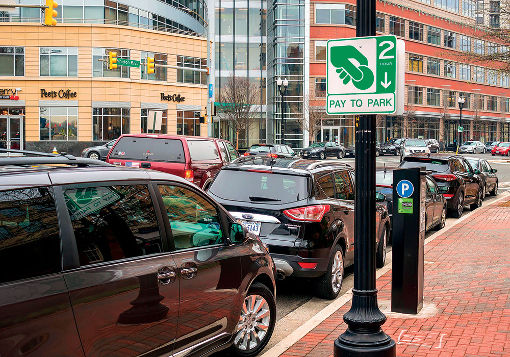 Curbs are evolving from places to merely park cars — as in Arlington, Virginia — into individual multimodal hubs, with a variety of modes zipping in and out. A single parked car curbside simply can’t compete with the capacity potential of taxi and TNC rides, transit stops, and bike lanes. Photo by Rob Crandall/Alamy.