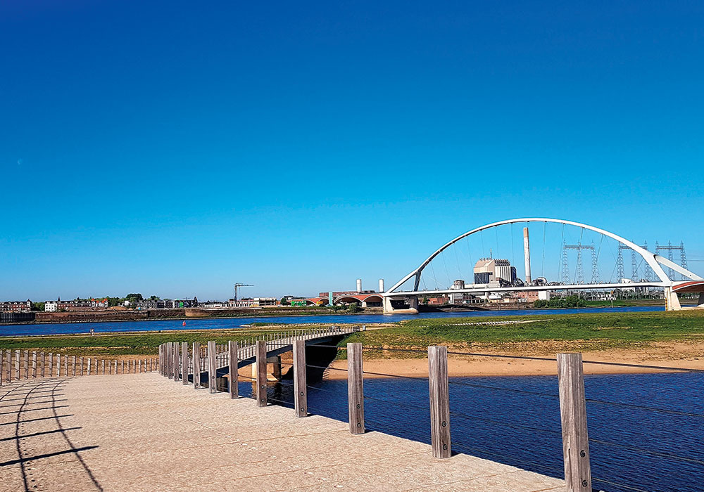 Room for the River projects restore floodplains while providing recreational amenities for the cities they protect. Here, bridges over the river Waal in Nijmegen, which got a new island and beach in the process. Photo by Jasper Ragetlie, iStock/Getty Images Plus.