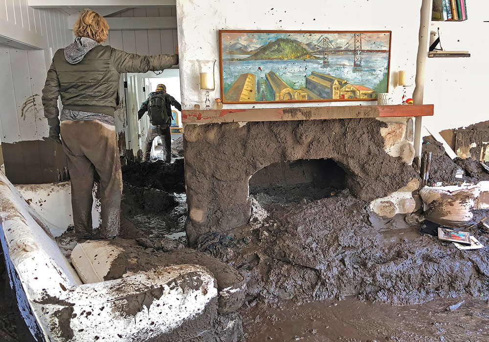 Relatives of Montecito resident Rebecca Riskin search for her belongings in her mud-filled living room. Riskin and her husband were swept away the morning of January 9, 2018, by the debris and boulder-filled San Ysidro Creek. Riskin’s body was found later; her husband was rescued by helicopter. Photo by Mike Eliason/Santa Barbara County Fire Department.