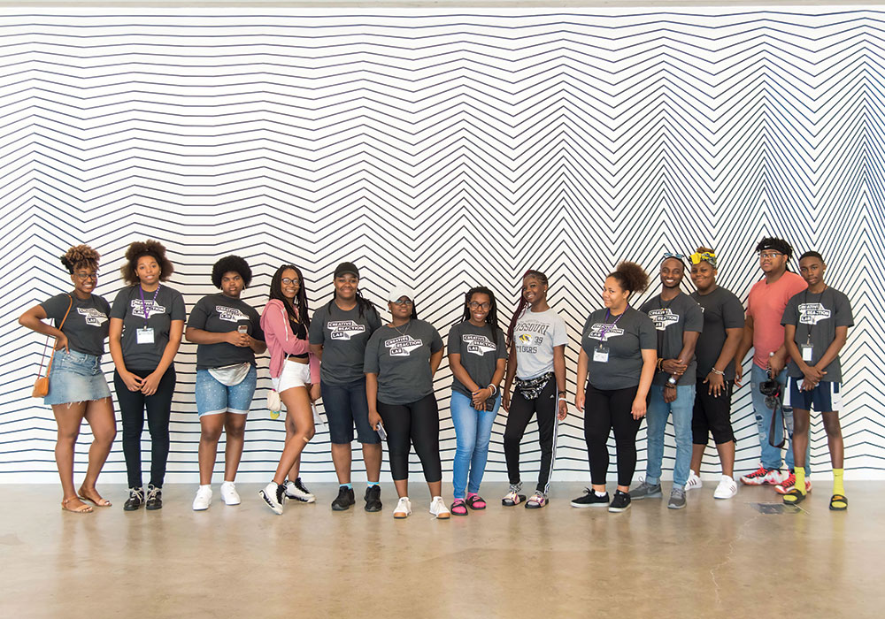 Design to Better [Our Community] youth leaders take a break for a group photo while canvasing the Grand Center Arts District to ask community members what they would like to change about St. Louis. Photo courtesy Creative Reaction Lab.