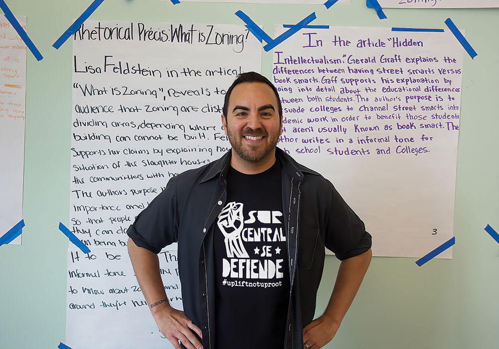 Jonathan Pacheco Bell stands with work by 12th grade students at East Los Angeles Renaissance Academy. Their project examined zoning history and planning theory concepts. Photo courtesy Jonathan Pacheco Bell.