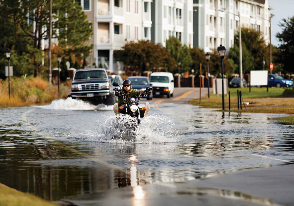 Motorists drive through a flooded street in Norfolk, Virginia, during a period of high-tide flooding. Climate change is causing these episodes to occur more frequently. Photo by Will Parson/Chesapeake Bay Program.