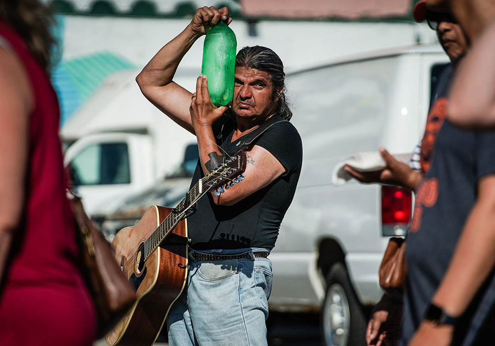 A performer cools off at the Des Moines, Iowa, Farmers Market during a heatwave in 2019. In the U.S., the average number of days per year with a heat index above 100⁰F is expected to double by 2036. Photo by KC McGinnis/The New York Times.