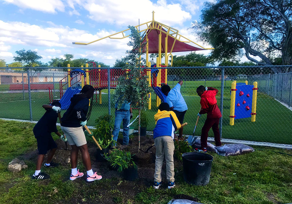 Members of a 5th grade class in Miami plant trees and other greenery around their playground during a 2019 Earth Day event, part of Neat Streets Miami’s Million Trees Miami initiative, aimed at achieving a 30 percent tree canopy in Miami-Dade County. Photo courtesy Neat Streets Miami.