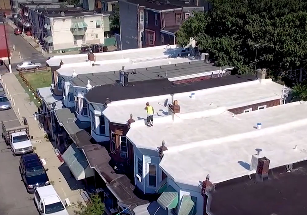 Members of the Roof Coatings Manufacturers Association cover roofs with rubberized white paint in Philadelphia to help keep buildings cooler. The city’s Beat the Heat program identified cool roofs as one tool against the heat island effect. Photo courtesy Energy Coordinating Agency Philadelphia.