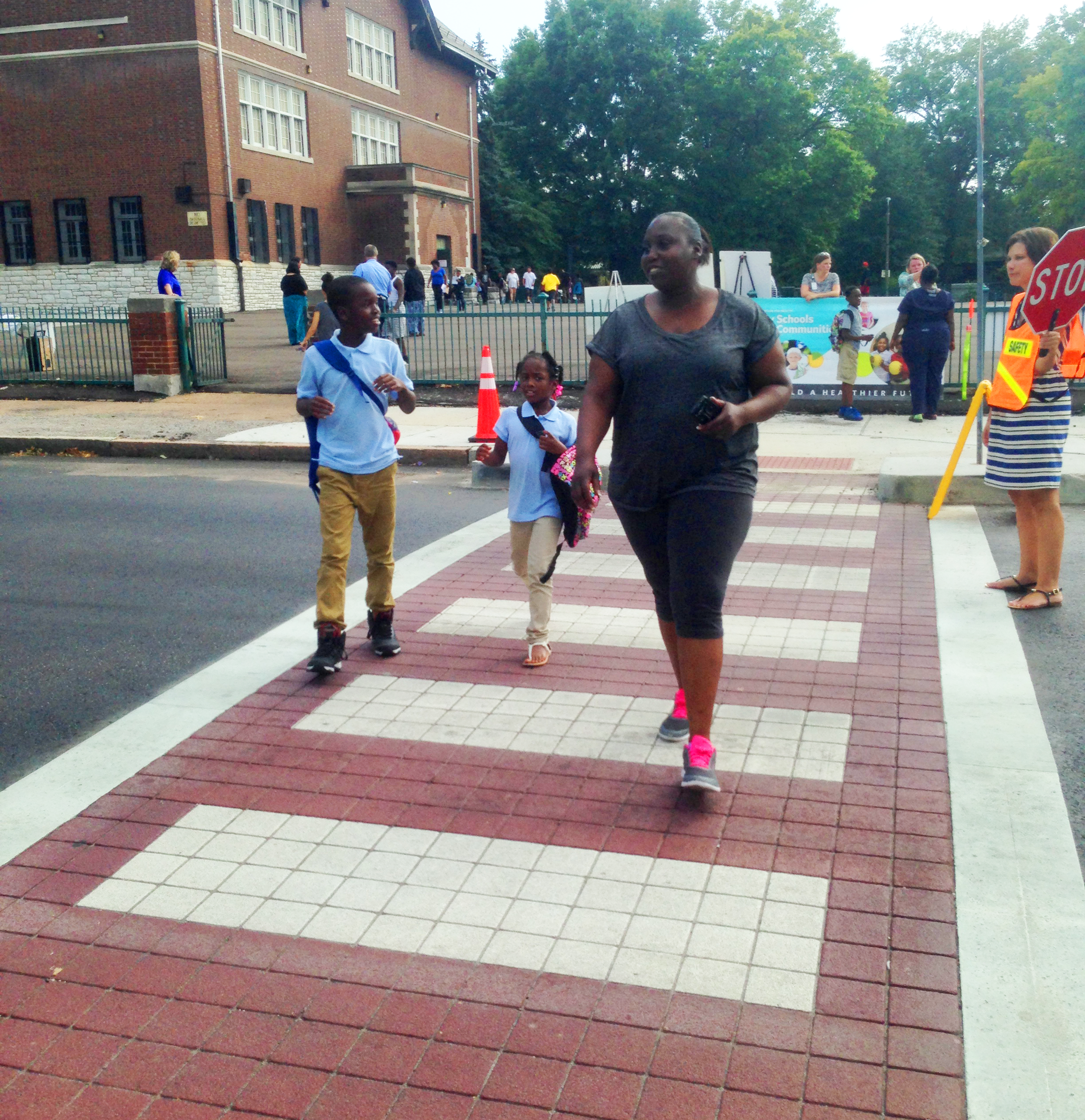 A family walks across the new crosswalk inspired by the Plan4Health project by Woodward Elementary School. Photo courtesy of Trailnet.