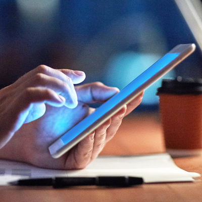 Hand touching glowing tablet screen Hand touching tablet screen on desk. Getty Images photo.