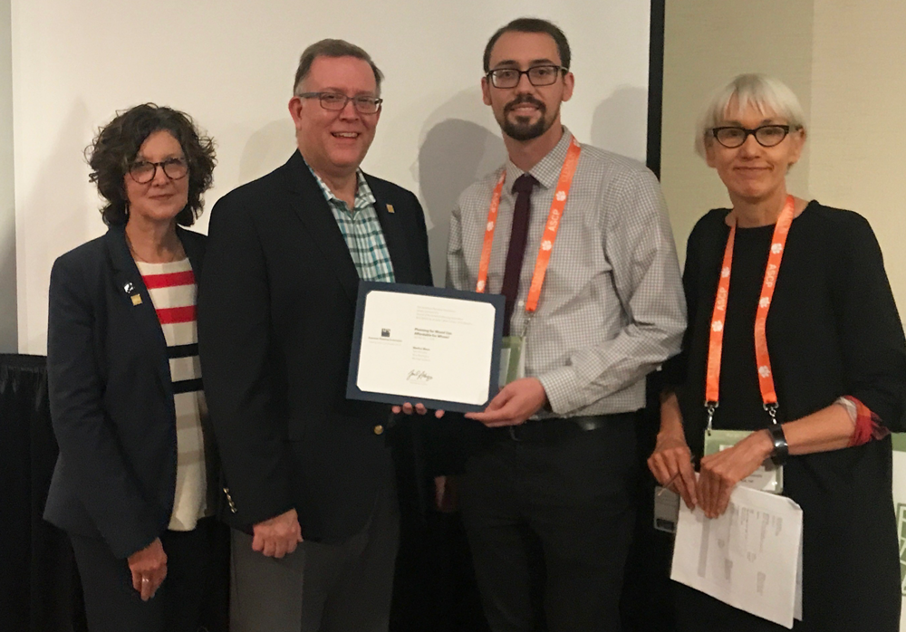 AICP President Deborah Lawlor, FAICP; APA President Kurt Christiansen, FAICP; and Journal of the American Planning Association Editor Ann Forsyth, PhD, present the 2019 JAPA Best Article by an Early Career Scholar Award to one of the article's co-authors, Nick Revington of the University of Waterloo, Canada (holding certificate), who accepted on behalf of award recipient Markus Moos.