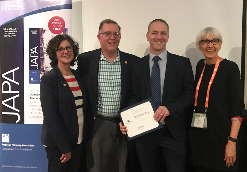 AICP President Deborah Lawlor, FAICP; APA President Kurt Christiansen, FAICP; and Journal of the American Planning Association Editor Ann Forsyth, PhD, present the 2019 JAPA Best Article Award to one of the three authors, Associate Professor Eoin O’Neill of University College Dublin (holding certificate). The presentation was made at the 2019 ACSP conference in Greenville, South Carolina.