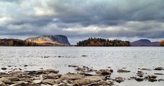 Landscape image of Mt. Kineo with Moosehead Lake in the foreground.